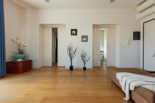 a bedroom with white walls and wooden floors and a bed at Villa Marcello in Cagliari