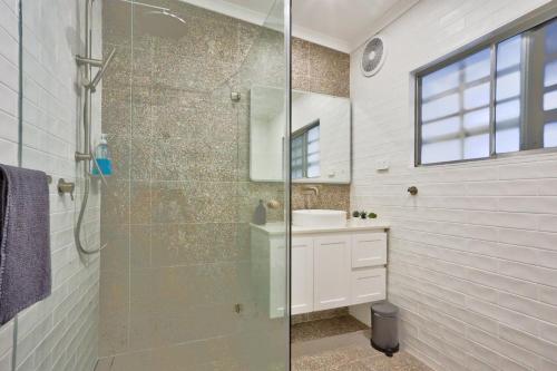 y baño con ducha acristalada y lavamanos. en Unique 2 Bedroom Darling Harbour Glebe 2 E-Bikes Included, en Sídney