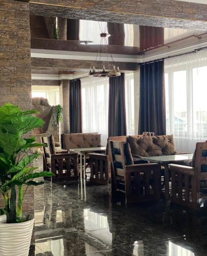 Una sala de estar con una mesa y sillas y un sofá. en Paradise Villa, en Taldykorgan