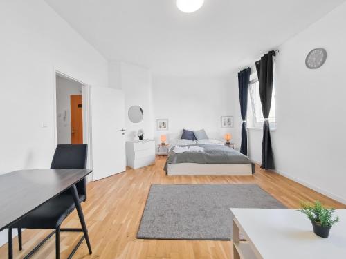 a white apartment with a bed and a desk at Brodschildstraße apartment in Stockerau