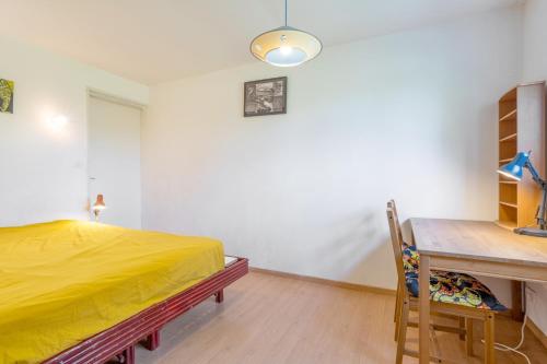a bedroom with a yellow bed and a desk at Belle grande maison vue mer in Tréogat