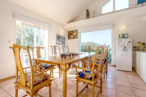 a kitchen and dining room with a wooden table and chairs at Belle grande maison vue mer in Tréogat