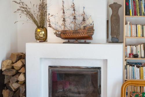a wooden boat sitting on top of a fireplace at Belle grande maison vue mer in Tréogat