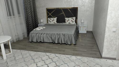 a bedroom with a large bed and a table at Гостиничный комплекс Paradise in Taldykorgan