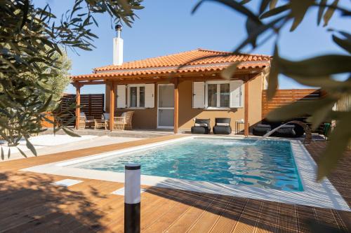 uma villa com piscina em frente a uma casa em Σπίτι με πισίνα δίπλα στο αεροδρόμιο. em Spata
