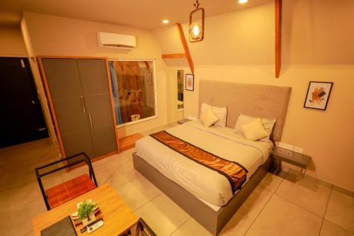 a bedroom with a large bed and a table at KAP KOROME VILLAGE RESORT in Koroth