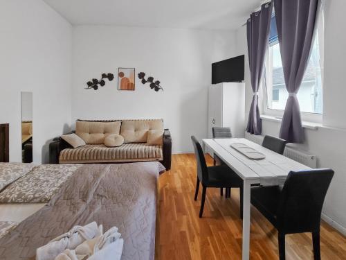 a bedroom with a bed and a table and a couch at Brodschildstraße apartment in Stockerau
