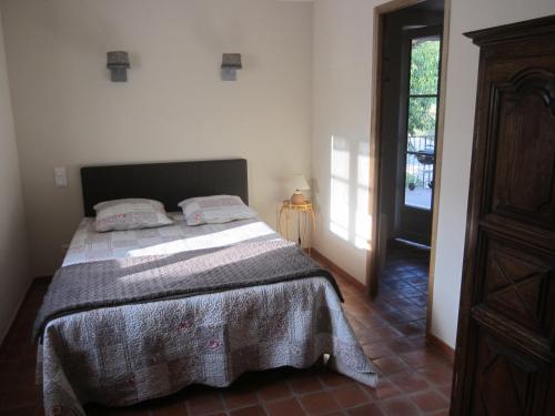 um quarto com uma cama num quarto com uma porta em Les Gites De La Gassende em Riez