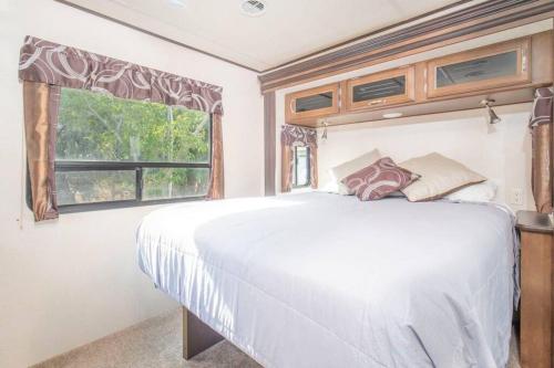 a bedroom with a large white bed and a window at Moab RV Resort Glamping RV Fully Setup OK42 in Moab