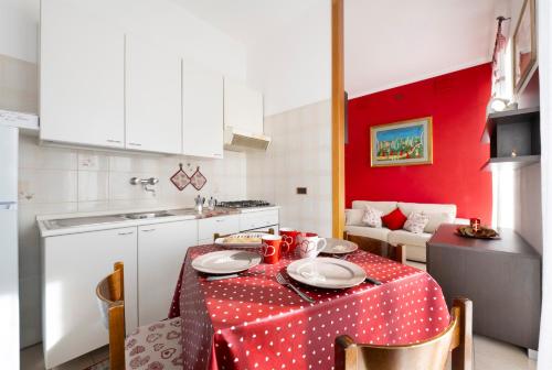 a kitchen with a table with a red and white table cloth at Bed & Breakfast Tiffany in Domodossola