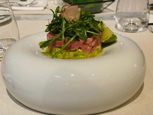 a white plate with a sandwich on a table at Hotel Brilliant Plaza in Zalău