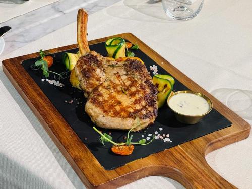 a plate of food with a piece of meat and vegetables at Hotel Brilliant Plaza in Zalău