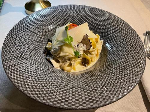 a bowl of food on a plate on a table at Hotel Brilliant Plaza in Zalău