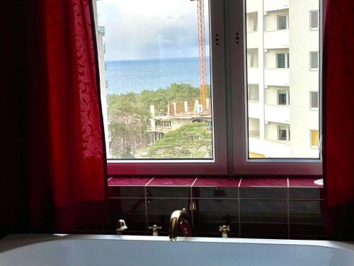 Okno łazienki z wanną i widokiem na ocean w obiekcie Apartament relax 4 w mieście Międzyzdroje