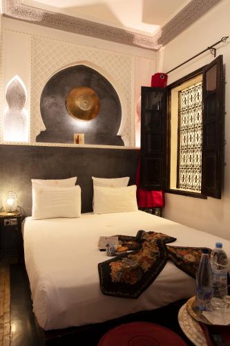 a bedroom with a large white bed in a room at Riad Alili in Marrakech