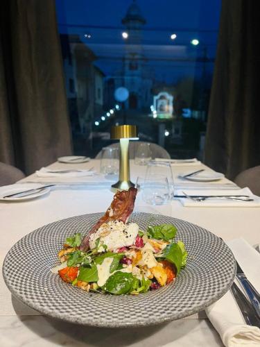 a plate with a salad on a table at Hotel Brilliant Plaza in Zalău