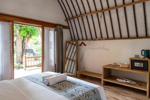 a bedroom with a bed and a large window at Villa Bagus in Gili Air