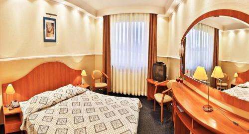 a hotel room with a bed and a mirror at Hotel Korona & Resteuracja in Cieszyn