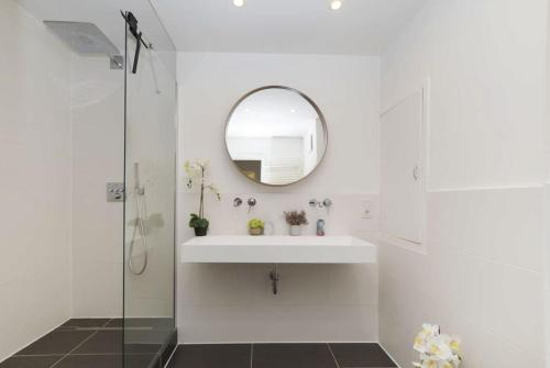 a white bathroom with a sink and a mirror at 2: Schöne Schwabing 70m² sannierte City Wohnung in Munich