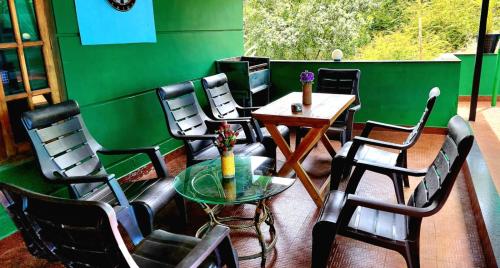 Habitación con sillas, mesa y pared verde en pookode villa, en Vythiri