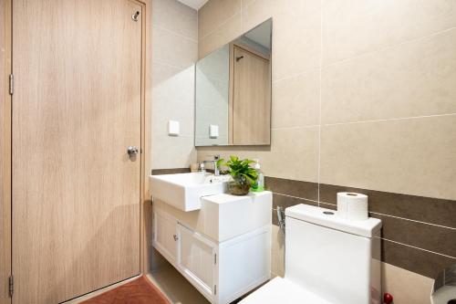 ein Badezimmer mit einem WC, einem Waschbecken und einem Spiegel in der Unterkunft Stay With Me Saigon Apartment - Rivergate Residence in Ho-Chi-Minh-Stadt