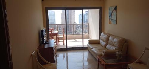 a living room with a couch and a large window at Apartamet Benidorm in Benidorm