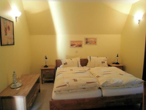 una camera da letto con un grande letto con lenzuola bianche di Gasthaus und Pension Zur alten Fähre a Porta Westfalica