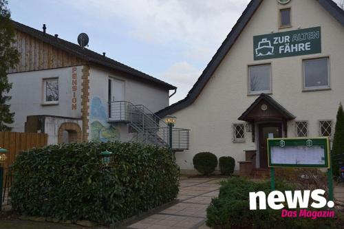 um sinal de notícias em frente a uma casa em Gasthaus und Pension Zur alten Fähre em Porta Westfalica