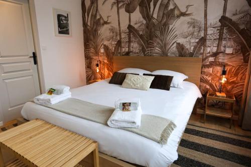 una camera da letto con un grande letto bianco con asciugamani di Au 38, Charme et Confort dans notre T2 à Epernay a Épernay