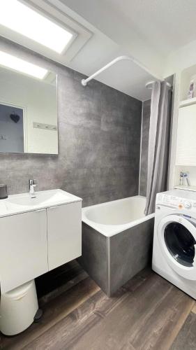 une salle de bain avec un lavabo et une machine à laver dans l'établissement Au pied des pistes Les 2 Alpes, à Les Deux Alpes