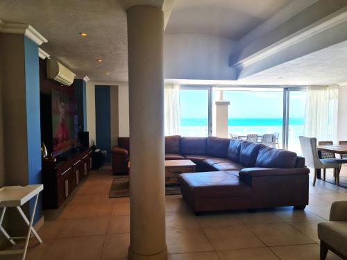 a living room with a couch and a table at Santorini A-Block Penthouse in Margate