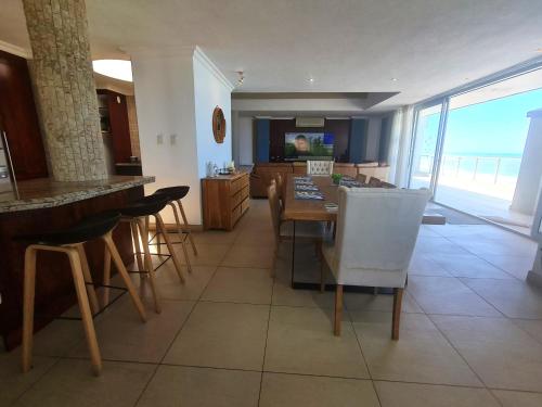 a kitchen and living room with a table and chairs at Santorini A-Block Penthouse in Margate