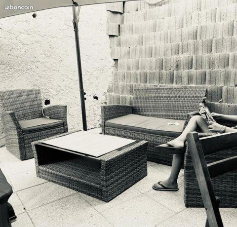 une femme assise sur une chaise sur un patio dans l'établissement Chez Aldo, à Ajaccio