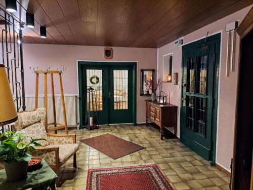Pension Waltermann في Balve: غرفة معيشة مع باب أخضر وطاولة
