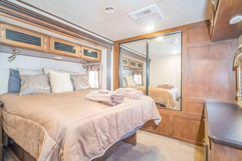 a bedroom with a large bed and a mirror at Moab RV Resort RV Fully Setup OK41 in Moab