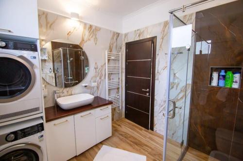 Un baño con lavadora y lavabo. en Luxury House, en Korçë