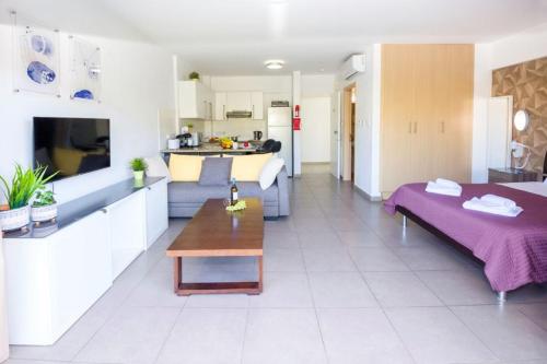 a living room with a bed and a kitchen at Lucile - Coralli Beachfront Apartment in Paralimni