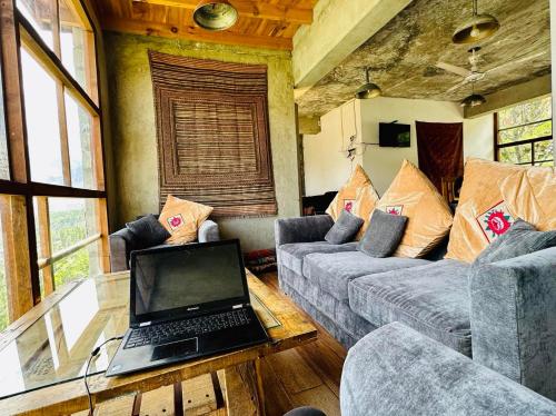 een woonkamer met een laptop op een glazen tafel bij Backpackers Stories by Old Hunza Inn in Hunza
