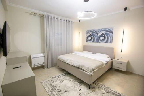 a bedroom with a bed and a painting on the wall at Luxury House in Korçë