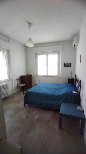 1 dormitorio con 1 cama, escritorio y 2 ventanas en Appartamento Gabriele, en Cattolica