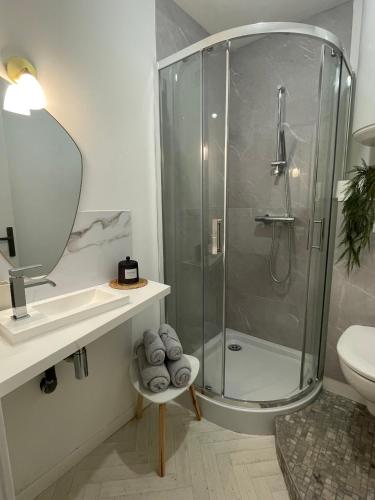 La salle de bains est pourvue d'une douche et d'un lavabo. dans l'établissement Stop'n'go - Parking privé - 5min d'Angoulême, à Soyaux