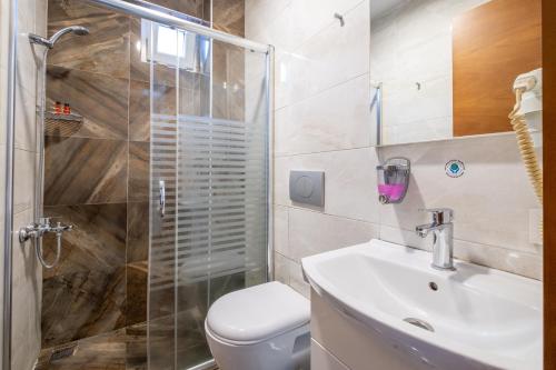 a bathroom with a shower and a toilet and a sink at The Dream Suite İstanbul in Istanbul