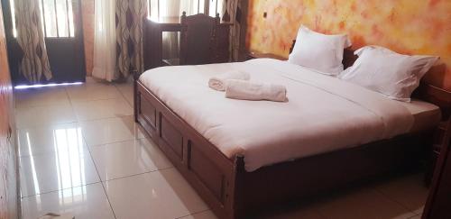 Una cama con una toalla blanca encima. en Mont Carmel Hotel, en Gisenyi