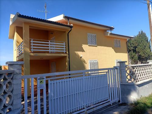 una casa con una recinzione bianca davanti di Villa Marina a Sorso