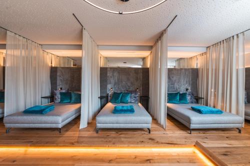 two beds in a room with blue pillows at Berg & SPA Hotel Urslauerhof in Maria Alm am Steinernen Meer