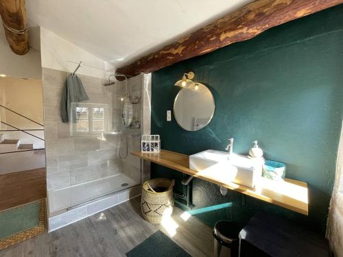 uma casa de banho com um lavatório e uma parede verde em L'Oustal de la Calade em Valleraugue
