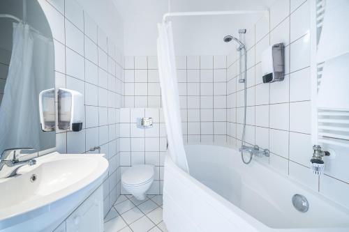 ハフナルフィヨルズゥルにあるホテル バイキングの白いバスルーム(バスタブ、トイレ、シンク付)