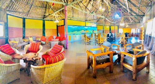 a living room with chairs and a table in a room at Explore Nature Lodge in Ololaimutiek