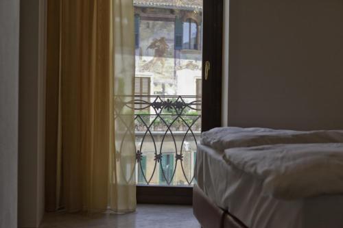 Schlafzimmer mit einer Tür, die auf einen Balkon führt in der Unterkunft Residenza Madonna Verona in Verona