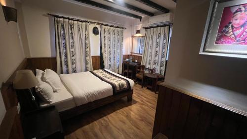 a bedroom with a bed and a desk in it at Hotel Yechu in Bhaktapur